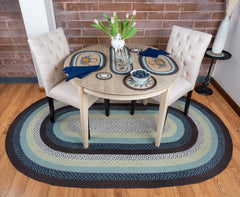 Blue braided rug with light and dark shades of blue, grey and white under table setting with blueberry theme.