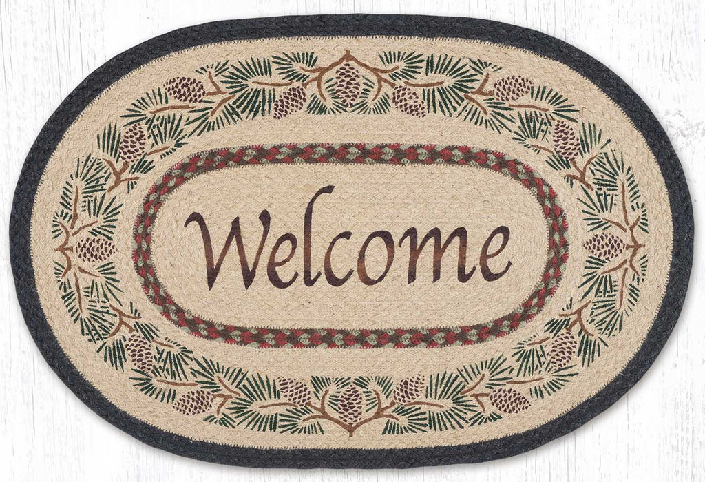 Welcome rug with pinecone border design. Grey, tan, brown, and green colors. Braided jute fibers.
