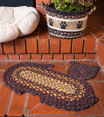 Cat-shaped pet rug made from braided jute next to cat bed.