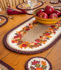 Braided table runner with autumn themed design. Burgundy and black border with natural tan jute center.