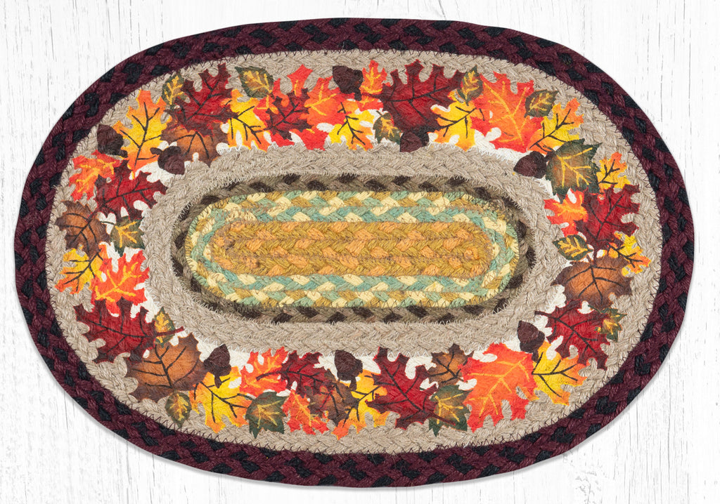 Oval braided placemat with autumn leaves design in orange, yellow, red and brown. Made from braided jute. 