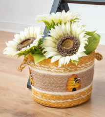 Braided jute basket with bee and beehive designs. 