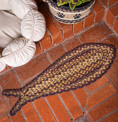 Fish-shaped pet rug made from braided jute next to cat bed