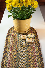 Braided table runner with brown, yellow, tan, green, and red colors with fall flowers and pumpkins